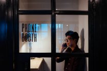 Азиатский мужчина в очках разговаривает по мобильному телефону — стоковое фото