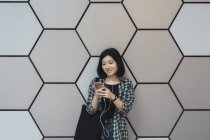 Молода красива азіатська дівчина в повсякденному одязі за допомогою смартфона на міських вулицях — стокове фото