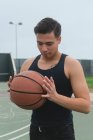 Giovane uomo che tiene un pallone da basket — Foto stock