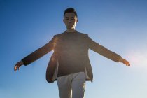 Junger asiatischer Mann gegen blauen Himmel — Stockfoto