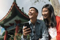 Asiatique couple chinois à l'aide de téléphone portable à Chinatown — Photo de stock