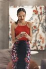Молодая привлекательная азиатка с помощью смартфона — стоковое фото