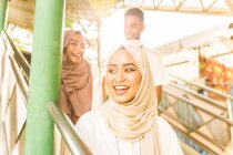 Joven grupo musulmán sonriendo en la escalera - foto de stock