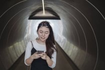 Chinese long hair woman standing in tunnel — Stock Photo