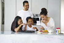 Junge asiatische Familie feiert Hari Raya gemeinsam zu Hause und kocht traditionelle Gerichte — Stockfoto