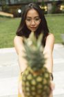 Femme chinoise montrant l'ananas à la caméra — Photo de stock