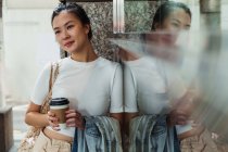 Giovane attraente donna asiatica con tazza di caffè — Foto stock