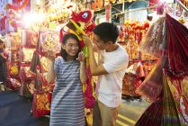 Young asian couple spending time together on traditional bazaar at Chinese New Year — Stock Photo