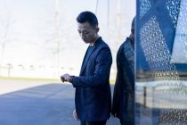 Junger asiatischer Mann kontrolliert Zeit auf der Stadtstraße — Stockfoto