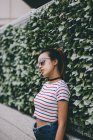 Portrait of Young hipster woman posing near bush — Stock Photo