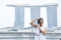 Young girl shooting on her camera at Raffles Place, Singapore — Stock Photo