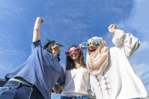 Групи друзів, смішні окуляри веселяться проти синього неба — стокове фото