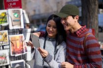 Asiatisches Paar schaut sich Postkarte als Souvenir an — Stockfoto