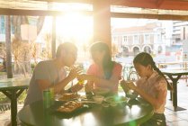 COMMUNIQUÉS Happy young asian family eating together in cafe — Photo de stock