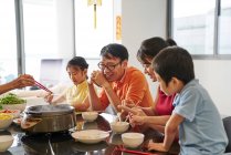 BESUCH Glückliche asiatische Familie beim gemeinsamen Essen am Tisch zum chinesischen Neujahr — Stockfoto