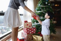 Asian family celebrating Christmas holiday, mother and son sharing gift — Stock Photo