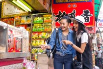 Duas namoradas estão se divertindo comprando comida de rua em Chinatown, Tailândia — Fotografia de Stock
