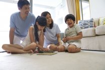 Siblings playing Scrabble indoors — Stock Photo
