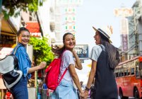 Tres chicas asiáticas bonitas están caminando y divirtiéndose en Chinatown, Bangkok - foto de stock