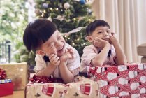 Щасливі азіатські хлопчики святкують Різдво разом з подарунками — стокове фото