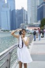 Giovane ragazza che gira sulla sua macchina fotografica a Raffles Place, Singapore — Foto stock