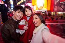 Familia feliz pasando un buen rato en Times Square en Nueva York - foto de stock