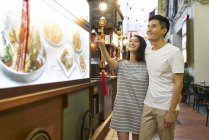 Junges asiatisches Paar shoppt im Café — Stockfoto