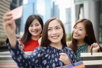 Joven asiático atractivo mujeres tomando selfie con compras bolsas - foto de stock