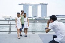 Giovane ragazza che gira sulla sua macchina fotografica a Raffles Place, Singapore — Foto stock