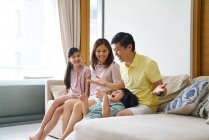COMMUNIQUÉS Happy young asian family together having fun at home — Photo de stock