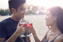 Attractive young asian couple having drink — Stock Photo