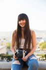 Schöne junge eurasische Frau posiert mit Kamera — Stockfoto