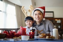 Père et fils à la table célébrant Noël ensemble à la maison — Photo de stock