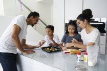 Young asian family celebrating Hari Raya together at home and cooking traditional dishes — Stock Photo