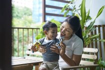 Asiatico madre interagendo con suo figlio a casa — Foto stock