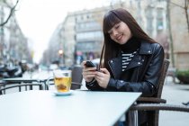 Молода приваблива азіатська жінка в місті за допомогою смартфона — стокове фото