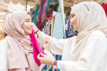 Two young muslim women shopping for fabric — Stock Photo