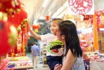 Счастливая азиатская мать и маленький мальчик проводят время вместе в китайском новом году и покупки — стоковое фото