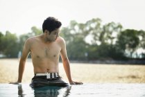 Giovane attraente asiatico uomo relax in piscina — Foto stock