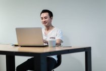 Junger asiatischer Mann arbeitet in modernem Büro — Stockfoto