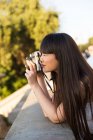 Young beautiful asian woman taking photo, side view — Stock Photo