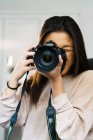 Portrait of young chinese woman with her camera — Stock Photo