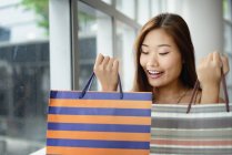 Jeune attrayant asiatique femme avec shopping sacs — Photo de stock