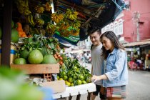 Young asian couple sightseeing in a local market in Ho Chi Minh City, Vietnam. — Stock Photo