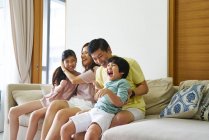 COMMUNIQUÉS Happy young asian family together having fun at home — Photo de stock