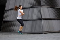 Молоді азіатські жінки гімнастика з мотузки стрибати на відкритому повітрі в Сінгапурі. — стокове фото