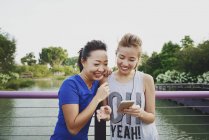 Молоді азіатські жінки використовують смартфон на відкритому повітрі — стокове фото