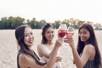 Attractive young asian friends having drink — Stock Photo