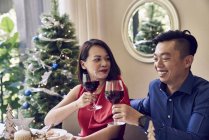 Feliz joven asiático amigos celebrando la Navidad junto con vino - foto de stock