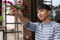 Young adult asian man pointing on something — Stock Photo